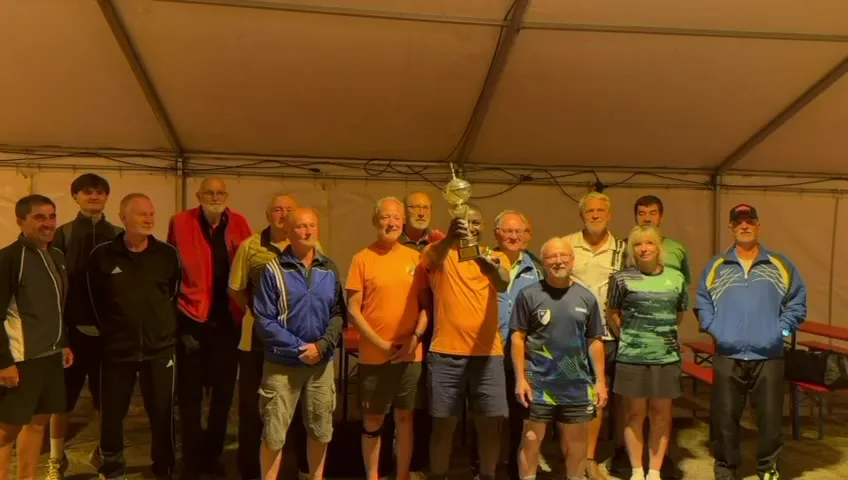Siegerehrung im Festzelt: Die Teilnehmer des Turniers um den Wanderpokal der SG Dissenchen 04, in der Mitte die SVH-Spieler in Orange mit dem Pokal