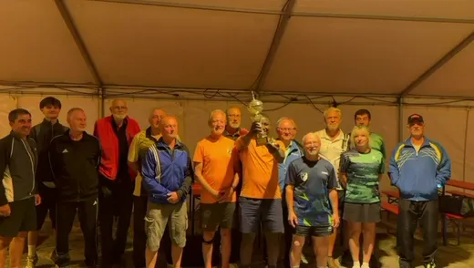 Siegerehrung im Festzelt: Die Teilnehmer des Turniers um den Wanderpokal der SG Dissenchen 04, in der Mitte die SVH-Spieler in Orange mit dem Pokal
